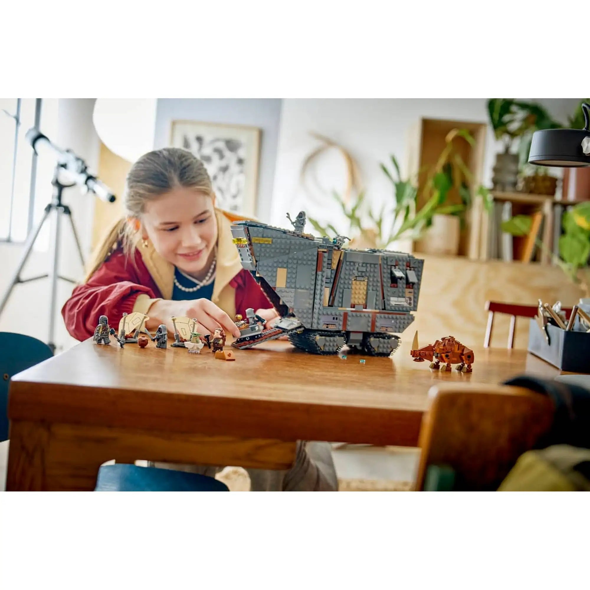 A LEGO Star Wars: Offworld homokkúszó és Mudhorn 75453 készlettel játszó gyermek a megépített homokkúszó mellett.