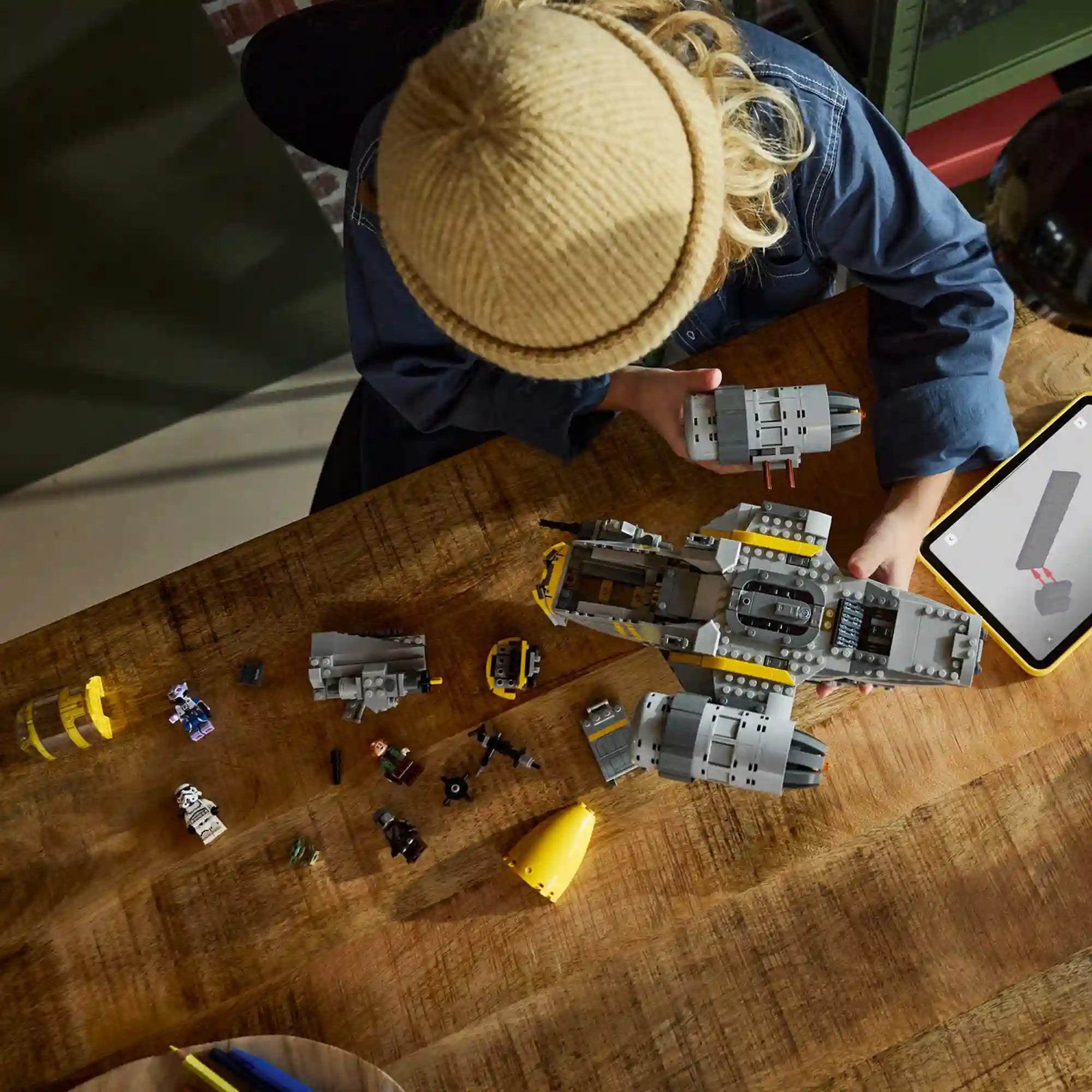 LEGO Star Wars 75447 The Razor Crest készlet építés közben, szétszedett elemekkel és minifigurákkal felülnézetből.