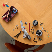 LEGO Star Wars Venator-osztályú támadó cirkáló építőkészlet szétszedett elemei egy faasztalon, külön panelek, talapzat és szerkezeti alkatrészek az építés bemutatására.