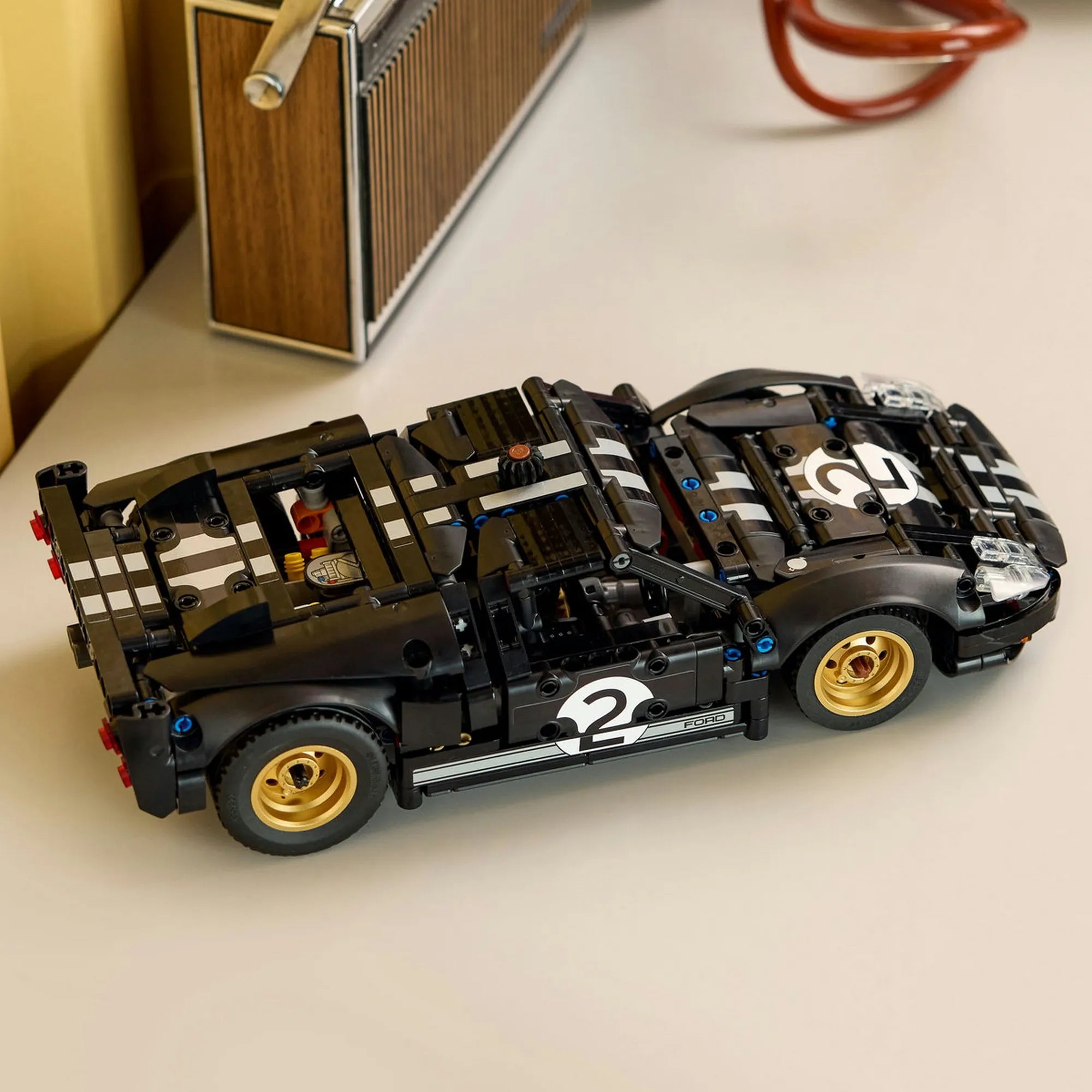 Megépített LEGO Technic 1966 Ford GT40 MKII versenyautó asztalon elhelyezve, klasszikus fekete-ezüst dizájnnal és arany színű felnikkel