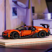 LEGO Technic Bugatti Chiron Pur Sport hiperautó narancssárga színben, polcon elhelyezve, sportos dizájnnal és fekete részletekkel