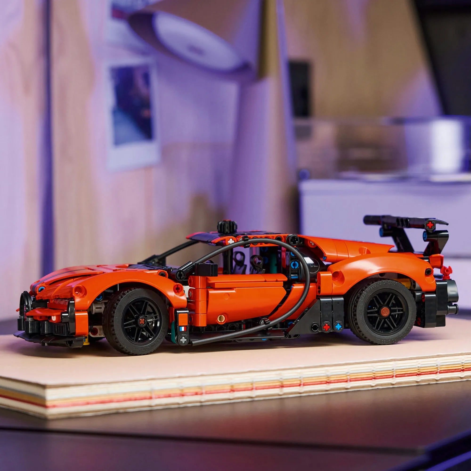 LEGO Technic Bugatti Chiron Pur Sport hiperautó narancssárga színben, polcon elhelyezve, sportos dizájnnal és fekete részletekkel