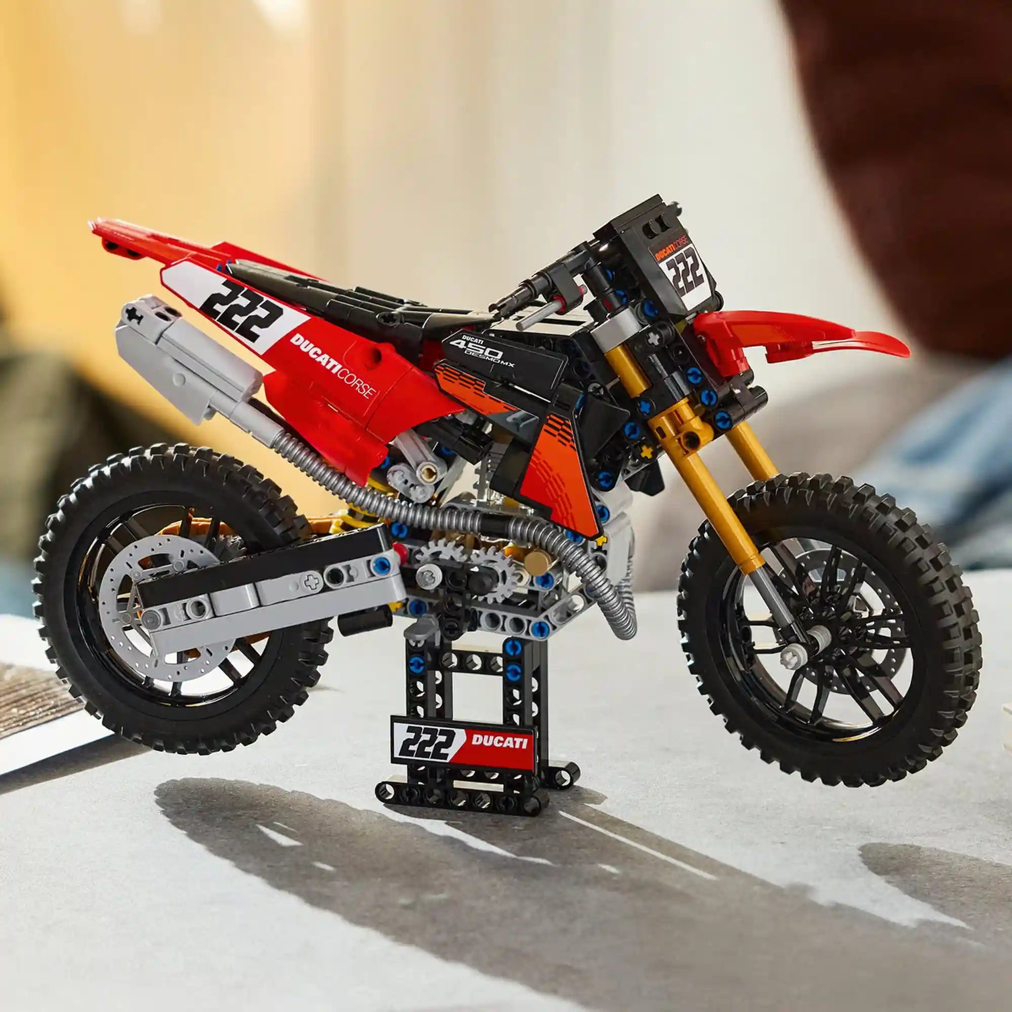 A LEGO Technic: Ducati Desmo450 MX Factory motorkerékpár 42238 megépített modellje a tartóállványon.