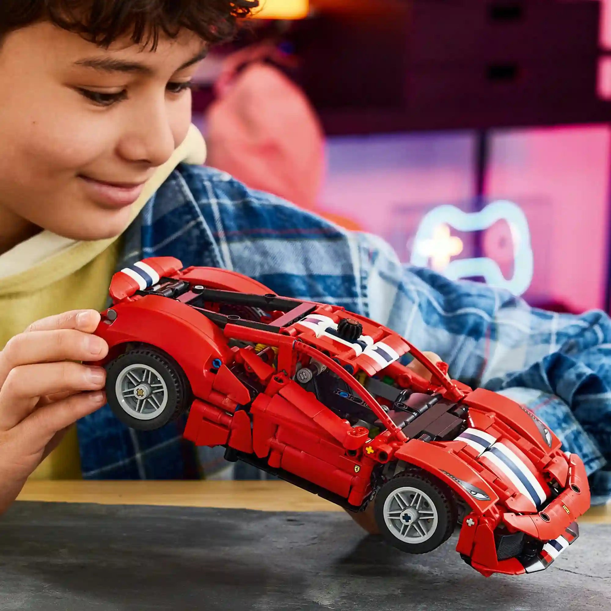 Egy gyermek a LEGO Technic: Ferrari 488 Pista 42235 megépített modelljével játszik.