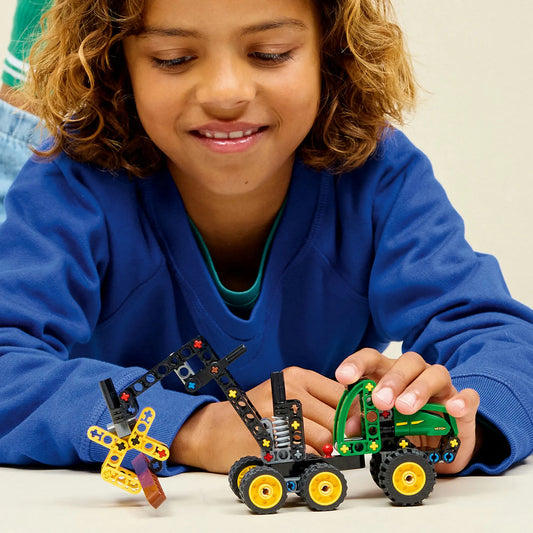 LEGO Technic: John Deere 1470H kerekes betakarítógép 42218 – Gyermek a megépített erdészeti munkagéppel játszik.
