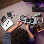 LEGO Technic Lamborghini Revuelto (42214) építés közben – Gyermek rakja össze a sportautót, mellette tableten 3D LEGO útmutató látható.