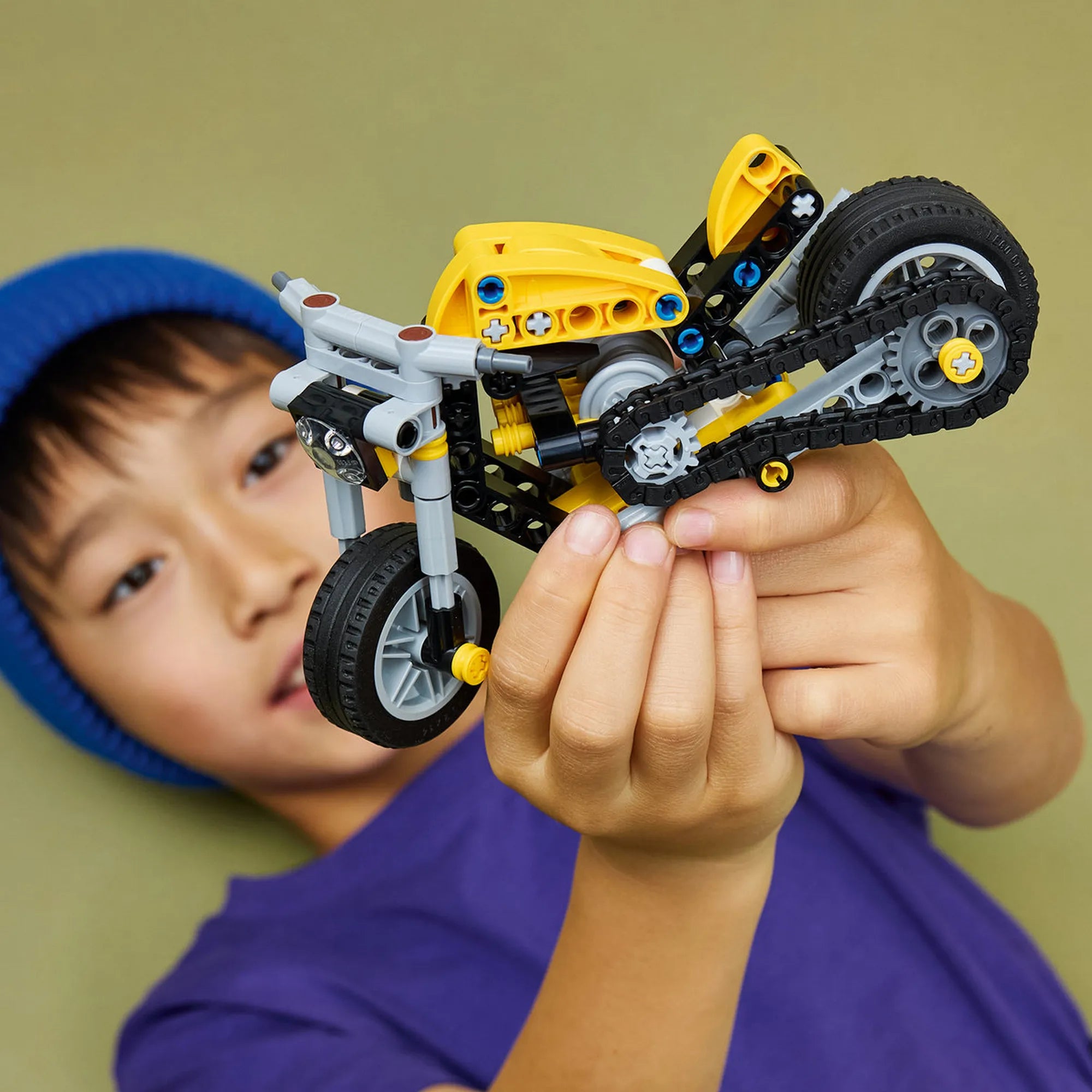 LEGO Technic: Sárga motorkerékpár 42225, 151 darabos – gyermek kezében tartott megépített Technic motor modell, amely bemutatja a játék méretét és részleteit.