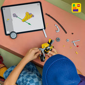 LEGO Technic: Sárga motorkerékpár 42225, 151 darabos – gyermek építi a modellt egy asztalnál, tablet képernyőjén digitális LEGO építési útmutató látható, körülötte Technic alkatrészek.