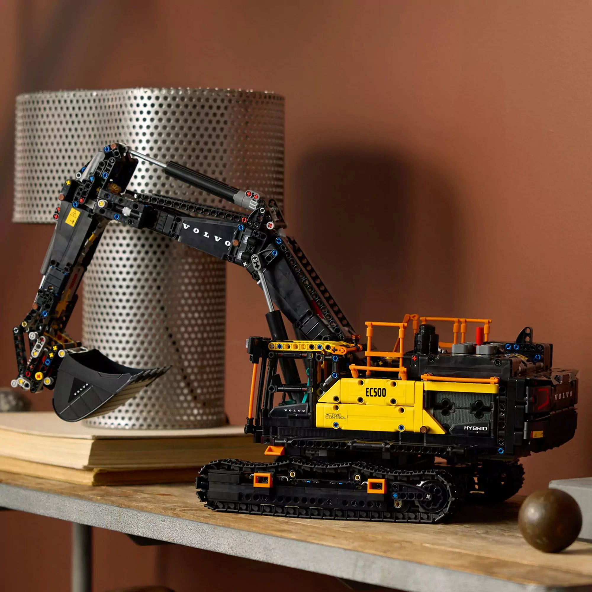 LEGO Technic Volvo EC500 Hybrid exkavátor (42215) kiállítva polcon – Az elkészült fekete-sárga LEGO exkavátor modell beltéri díszletben.