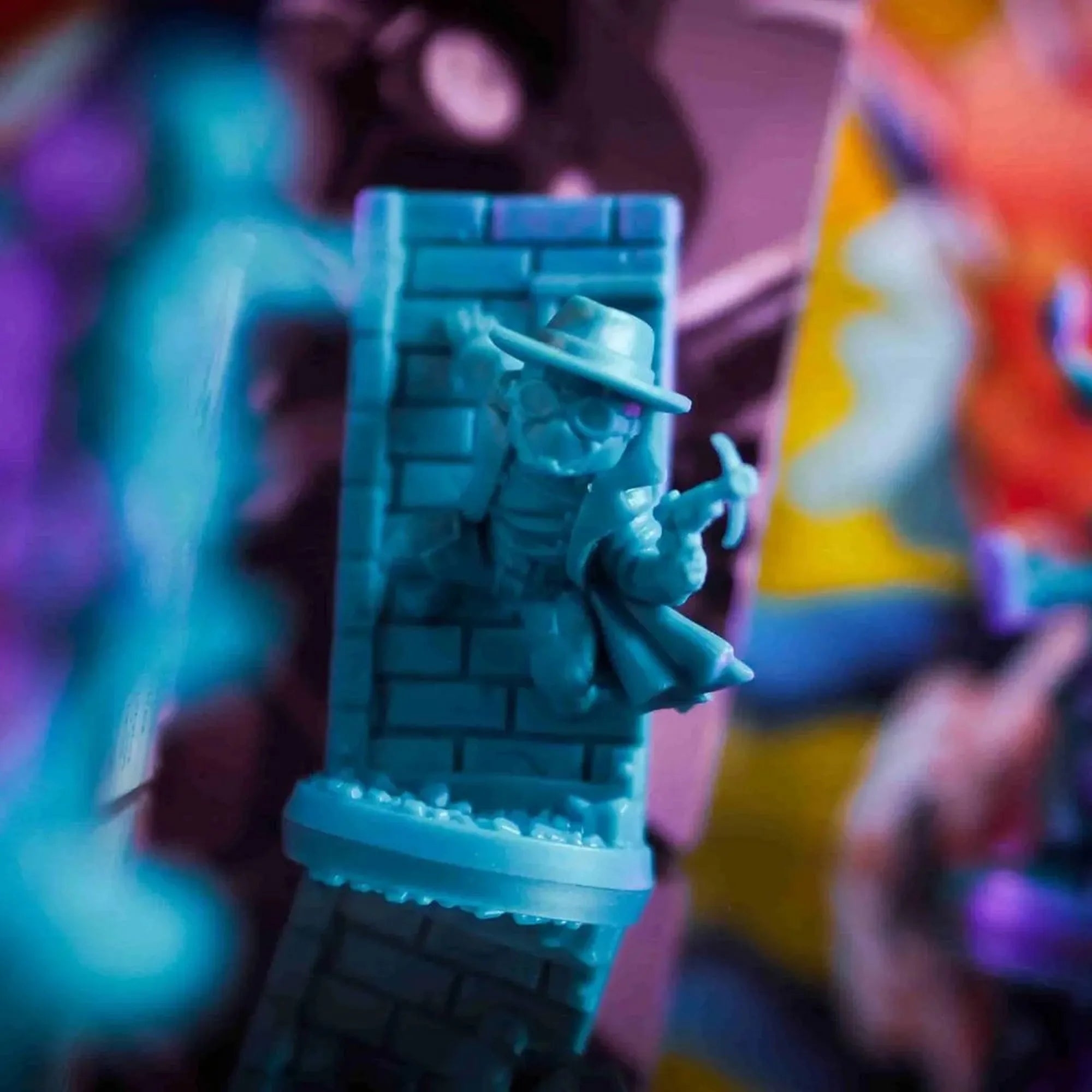 Marvel United: Spider-Geddon figura, amelyen Spider-Man Noir egy téglafal mögül kandikál elő, kalapban és ballonkabátban, kezében csákánnyal.