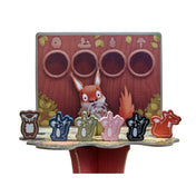 A Mókusfutam játékhoz tartozó mókus- és bagolyfigurák a felső játékszinten, mögöttük egy játékoskártya fatörzs mintával.