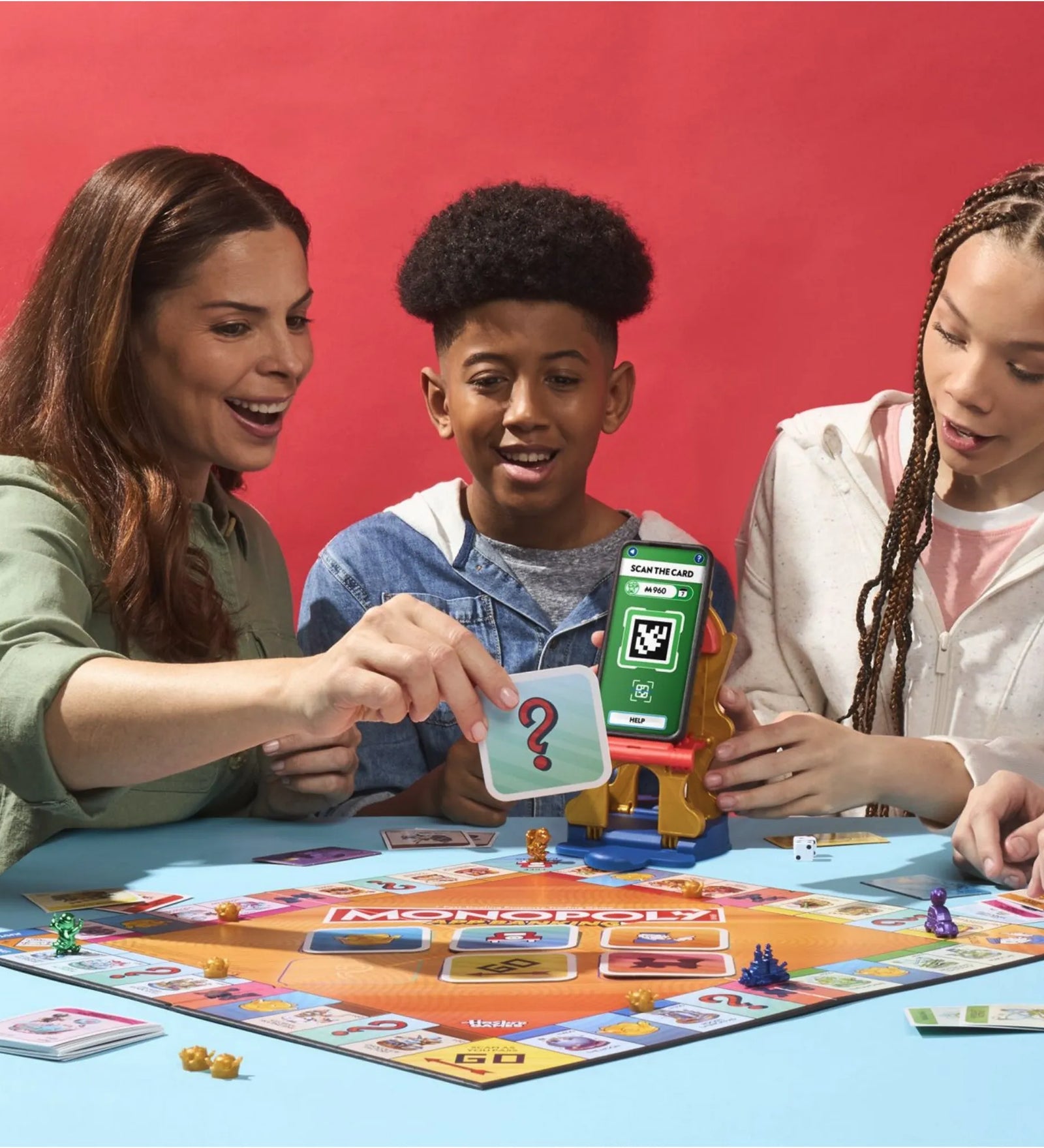 Monopoly App Banking társasjáték játék közben, gyerekek okoseszközzel és játéktáblával.