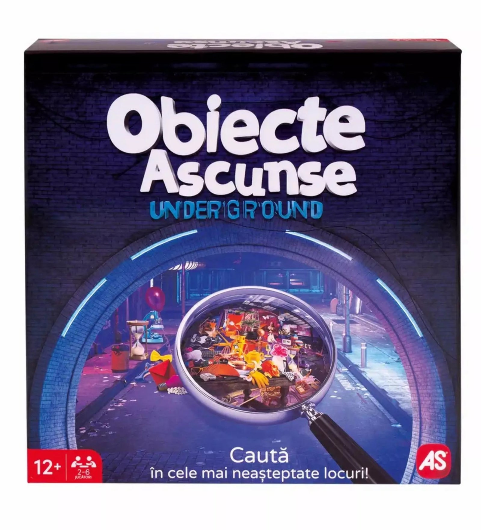 A „Obiecte Ascunse Underground” társasjáték doboza sötétkék háttérrel, középen egy nagyítóval, amely színes tárgyak tengerét emeli ki egy metróállomás hangulatú helyszínen.