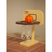 Plakks Basketball miniatűr kosárpalánkja hálóval és kosárlabdával közelről.