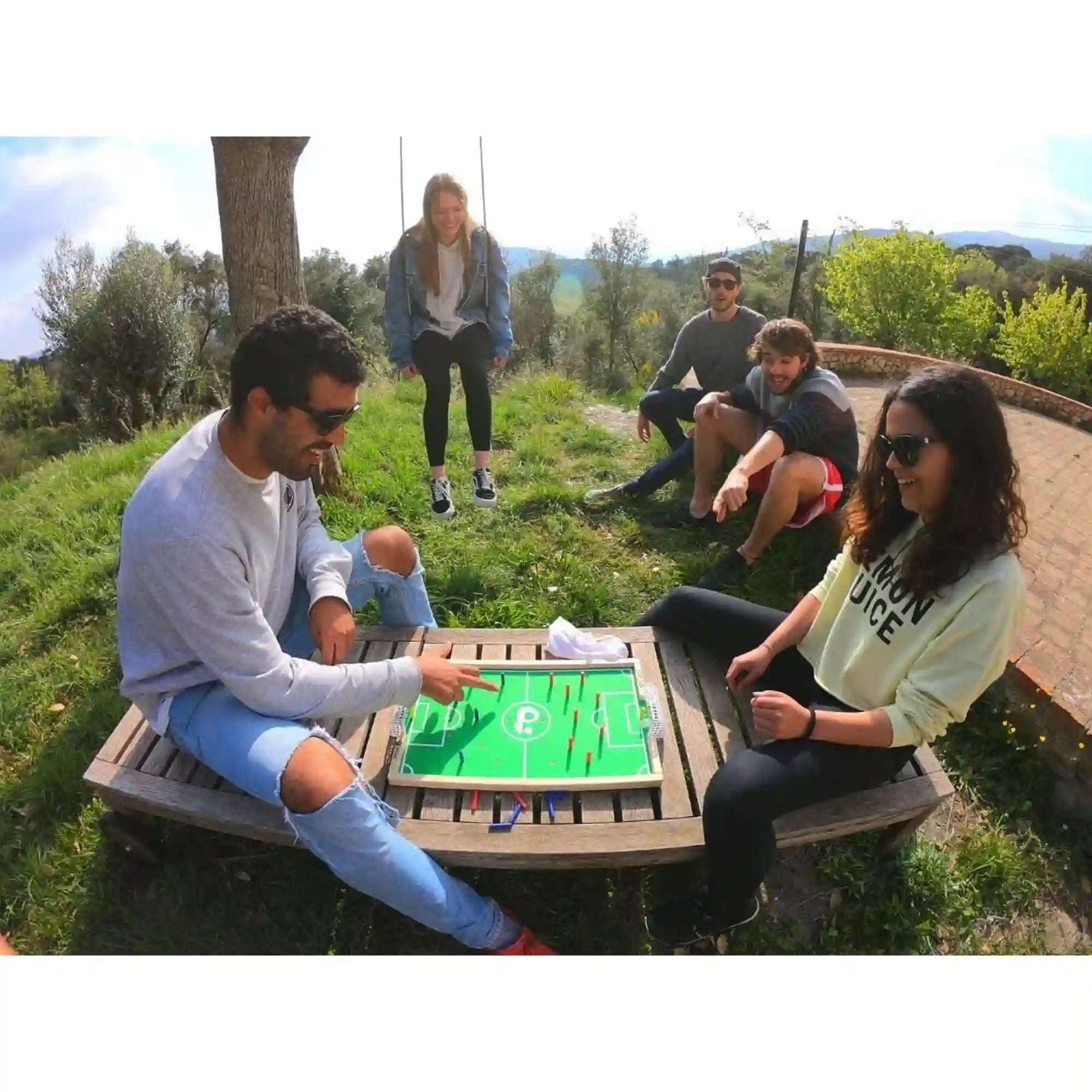Baráti társaság Plakks Football játékkal játszik a szabadban.