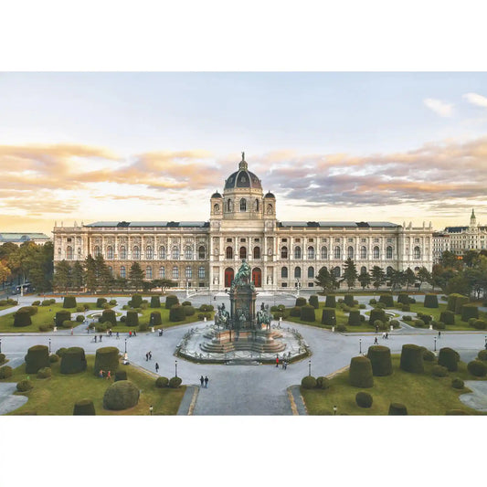 Puzzle Piatnik: Bécsi Szépművészeti Múzeum, 1000 darabos kirakó képe, amely a bécsi Szépművészeti Múzeum monumentális épületét és a Maria-Theresien-Platz parkját ábrázolja naplementés fényekben.