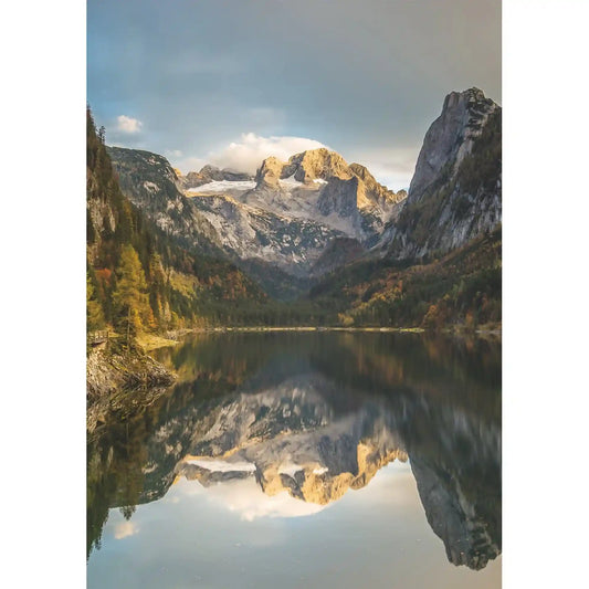 Dachstein-hegység lenyűgöző alpesi tájképe kristálytiszta hegyi tóval, hófödte csúcsokkal és tükörsima vízfelszíni visszatükröződéssel.