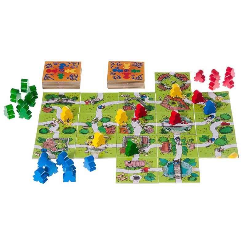 Carcassonne Junior játék közben kirakott pálya színes figurákkal és kártyapaklival